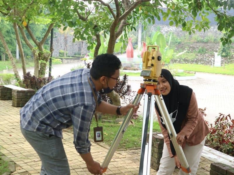 Land survey crew performing a residential land survey using surveying equipment
